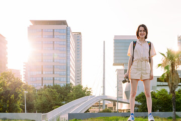 happy young traveler with camera at city