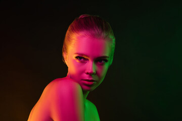 Mavelous. Portrait of female fashion model in neon light on dark studio background. Beautiful caucasian woman with trendy make-up and well-kept skin. Vivid style, beauty concept. Close up. Copyspace