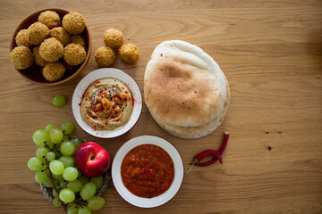 Israeli food close up photo. Falafels, hummea and pita bread on a table. 