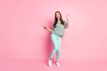 Fototapeta na wymiar Full size photo of cute pretty girl dancing wear shirt blue pants white sneakers isolated on pastel pink color background