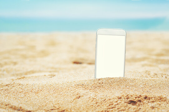 smartphone in the sand on a beach in the summer.
