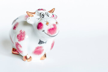 Porcelain figurine of a bull white and purple on a white background. New year of the bull