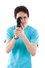 Studio photo of dark haired man with light blue t shirt using an old style camcorder. Isolated on white background.