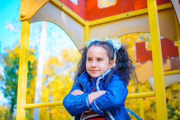 happy cute child, girl laughs and plays in the fall in nature, walks outdoors