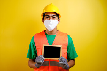 Fototapeta na wymiar Portrait of asian workman wearing protective mask holding small blackboard