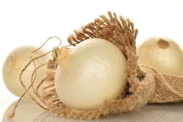 Ripe white organic onions, close-up, on a white background.