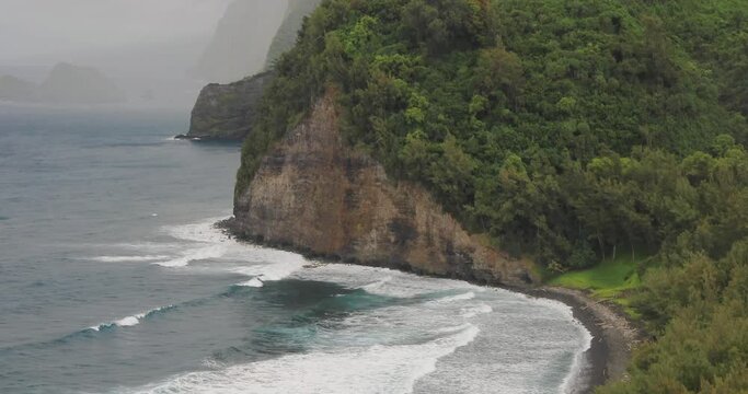 4k tilt panning motion from top to bottom view of Pololu Valley and the black sand Beach from the Lookout in rainy weather,Big Island, Hawaii, USA