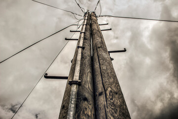 Double electric pole with lightning rod against the stormy sky