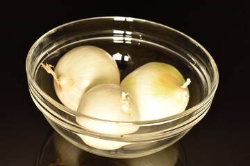 Fototapeta na wymiar Ripe white organic onions, close-up, on a black background.