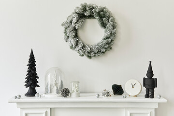 Christmas composition on the white chimney at the living room interior with beautiful decoration. Christmas tree and wreath, candles, stars, light. Copy space.  Template.