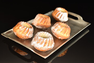 Fragrant sweet cupcakes, close-up, on a black background.