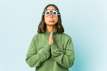 Young oculist latin woman over isolated background