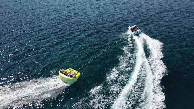 Aerial drone video of extreme powerboat donut watersports cruising in high speed in tropical turquoise bay