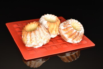 Fragrant sweet cupcakes, close-up, on a black background.