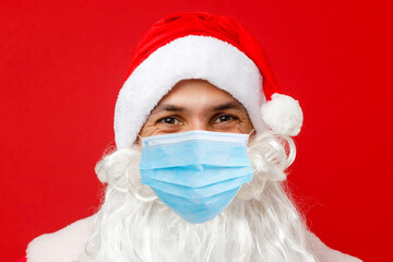 Fototapeta na wymiar Illness and colds. santa claus in medical mask. red background.