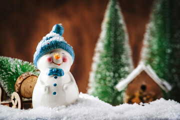 Merry Christmas and happy New Year composition with copy space. Little snowman carries Christmas tree from fairy forest to home. Winter festive background