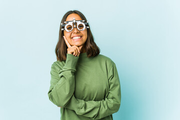 Young oculist latin woman over isolated background