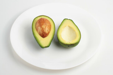 Two slices of avocado on a plate isolated on a white background. Top view
