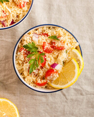 Flatlay Tabouleh is an Arabic vegetarian salad made with couscous, tomatoes, parsley. Healthy lunch
