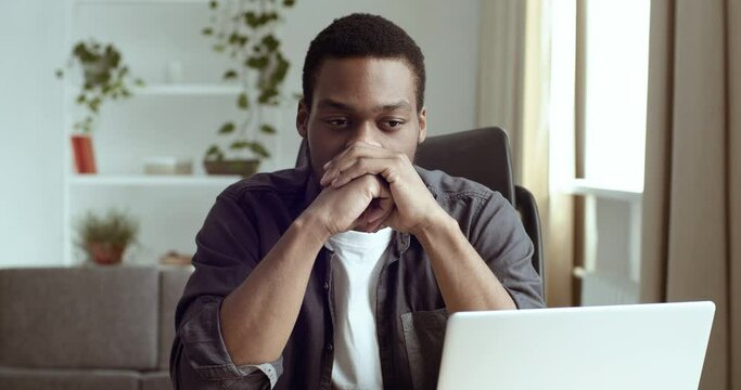 Portrait of pensive man business analyst freelancer author writer student sitting at table at home in front of computer with folded hands near chin thinking about project of creative idea dreaming