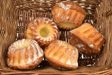 Fragrant sweet cupcakes, close-up, in a basket of vine.