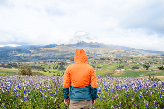 Young man standing in fron of Cotopaxi mountain in los Andes Ecuador
