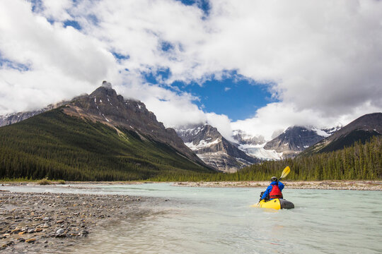 Man paddling on scenic river, Rocky mountains, Alberta, Canada.