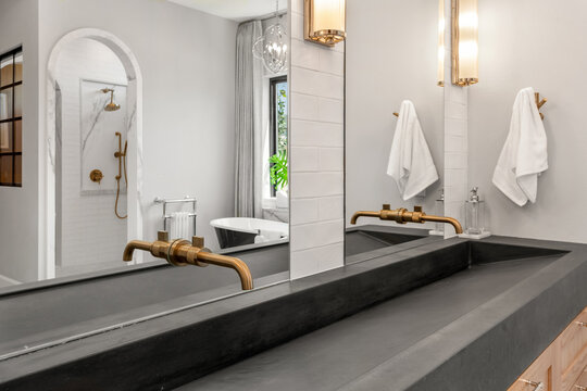 Bathroom in luxury home with concrete sink and double vanity