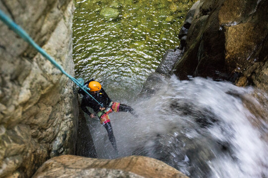 High angle view of man rappelling in down waterfall, West Vancouver.