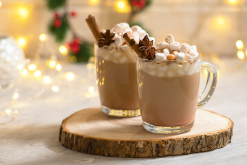 Spiced christmas drink latte with marshmallows on the celebration table with cinnamon and anise decoration
