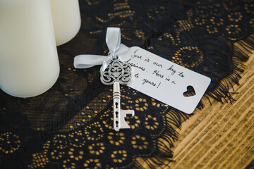 Silver Key Wedding Favor Tied with Handwritten Note on Black Lace with White Candles