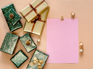 Christmas or New Year gifts in green and gold paper on beige background.  Top view.