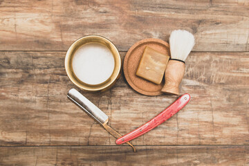 Matte.Men's straight razor, shaving brush, soap, shaving foam in a gilded container.