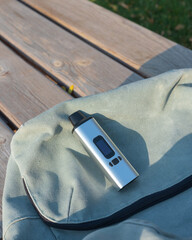portable herbal vaporizer lies on the surface of the backpack