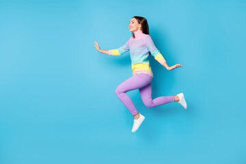 Fototapeta na wymiar Full length body size view of pretty dreamy cheery thin girl jumping walking having fun isolated over bright blue color background