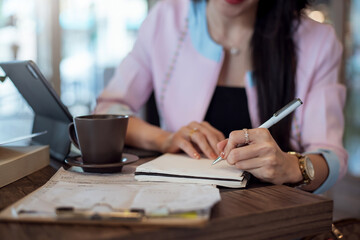 Fototapeta na wymiar Close up. Woman taking notes on desk at cafe.