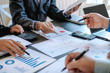 Group of business people meeting together Pointing to the graph assess business profits.