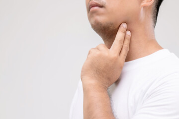Lymphoma in men concept : Portrait Asian man is touching on his neck at lymph node position. Studio shot isolated on grey