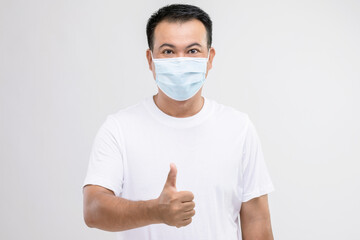 Portrait of Thai man wearing protective face mask to prevent virus studio shot on grey