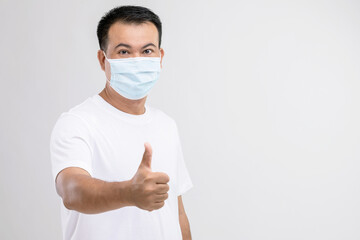 Portrait of Thai man wearing protective face mask to prevent virus studio shot on grey