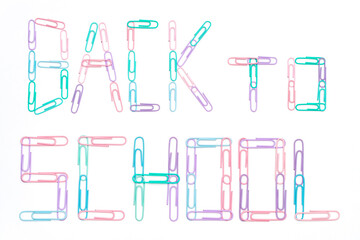 Back to school sign made of paperclips in various pastel colours isolated on white background. Education and typography concept