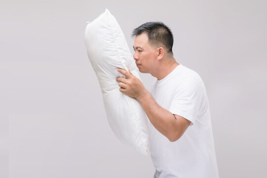 The Pillow Smells Bad. Portrait Asian Man Holding White Pillow And Getting Bad Smell. Studio Shot On Grey