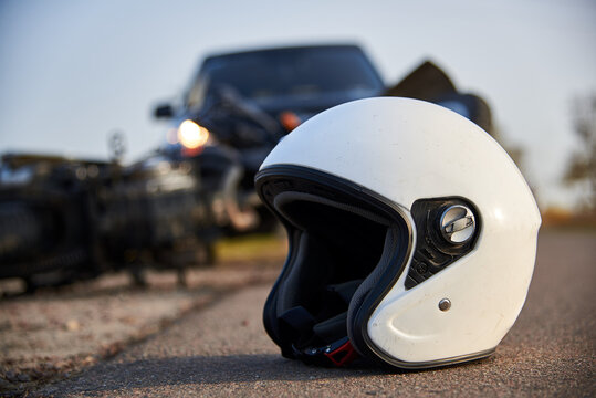 Photo of car, helmet and motorcycle on the road, the concept of road accidents.