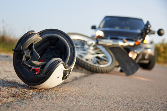 Photo of car, helmet and motorcycle on the road, the concept of road accidents.