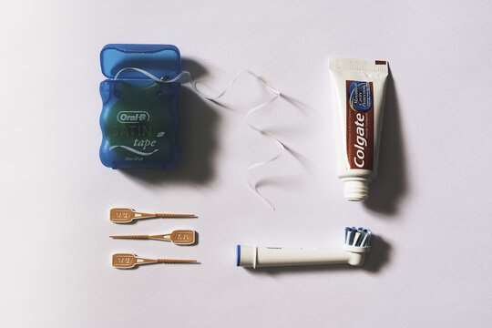 A flat lay image of dental accessories including tooth paste, dental floss, tee pee cleaning products and brushes. Set out in organised method against a white background with copy space