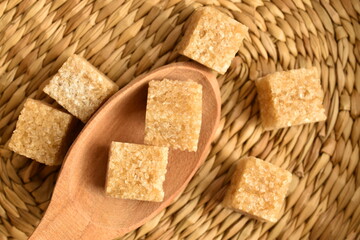 Several cubes of brown sugar, close-up, on a straw mat.