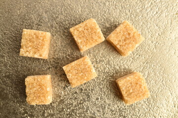 Several cubes of brown sugar, close-up, on a metal tray.