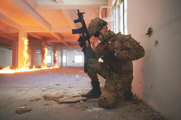 Fototapeta premium soldier in action near window changing magazine and take cover