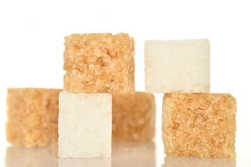 Several cubes of brown and white sugar, close-up, on a white background.