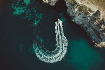boat in front of a rock in the black sea taken during the day from a quadrocopter
